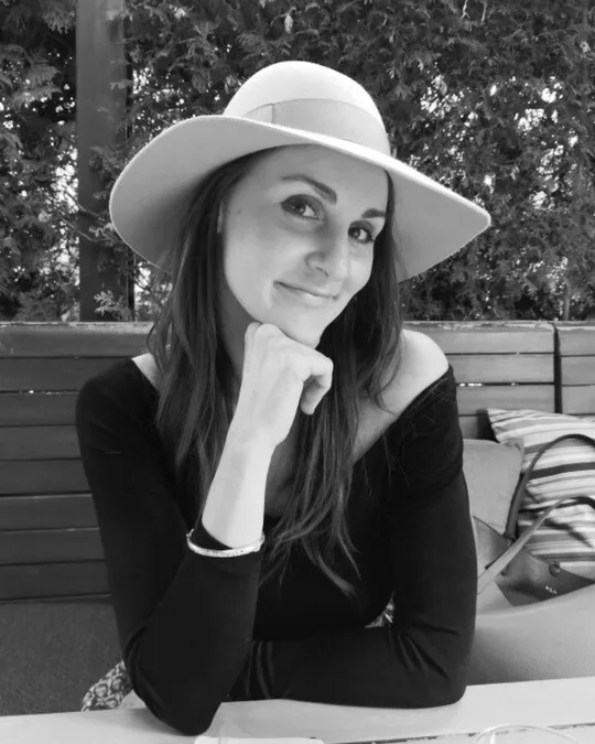 Kate Csák, smiling, in a wide-brimmed hat